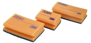 Drei orangefarbene Scotch-Brite Reinigungsschwämme mit blauen Unterseiten.