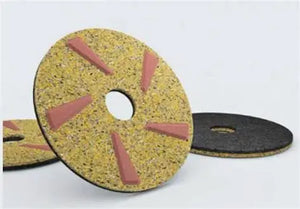 Ein gelbes Diamant-Reinigungs-Pad mit roten Einsätzen und einem Mittelloch.