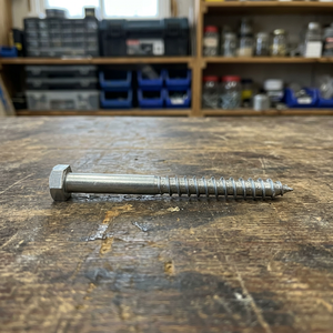 Sechskant-Holzschraube auf einer hölzernen Werkbank in einer Werkstatt.